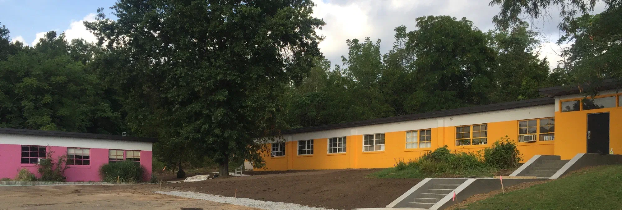 The pink and yellow studio buildings at Riker Hill Art Park, where the Art Centre meets